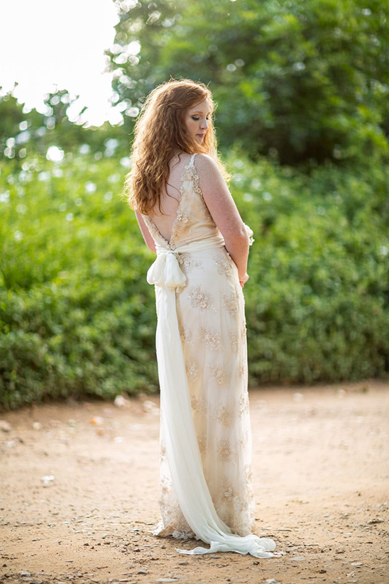Redhead bride in elegant lace wedding gown outdoors