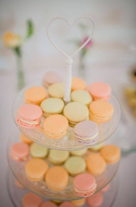 Pastel macarons on a tiered stand with a heart-shaped handle