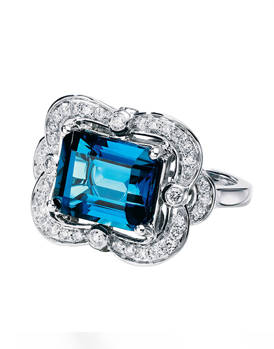 Elegant blue topaz ring with diamond accents and a floral setting