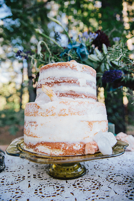 Two tier naked cake with crystal decorations outdoors