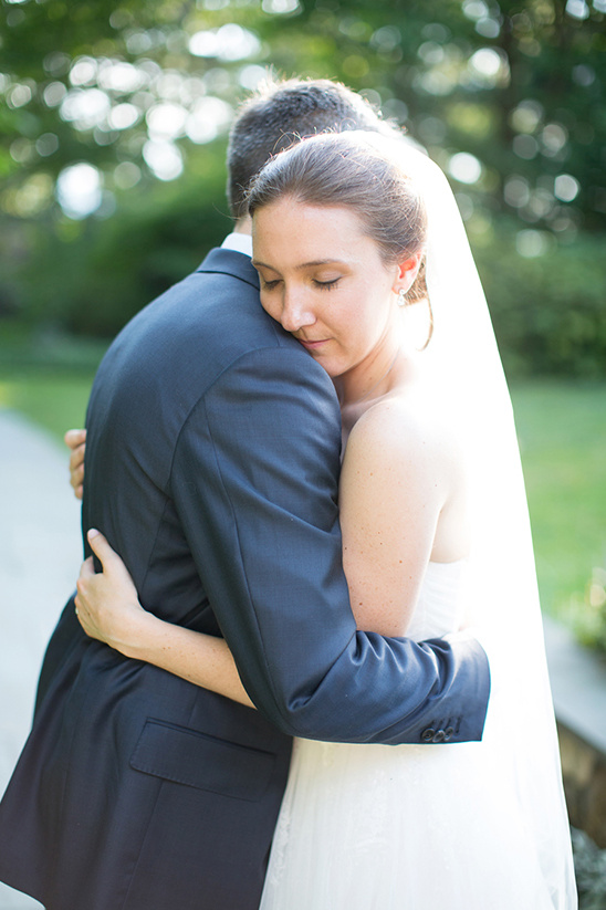 Bride and groom embrace on their wedding day outdoor ceremony