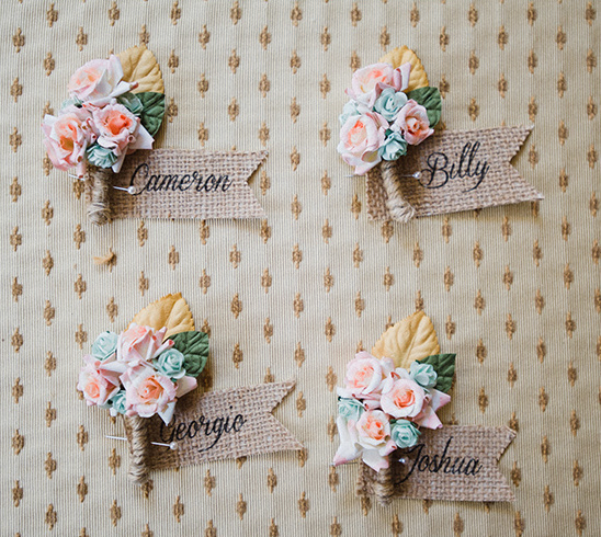 Boutonnieres with names on burlap tags for a wedding party