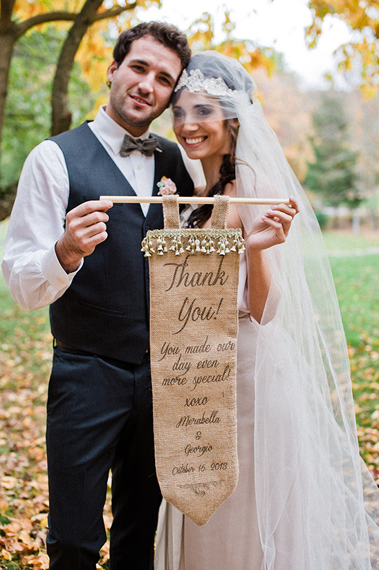 Newlyweds holding a thank you sign on their wedding day