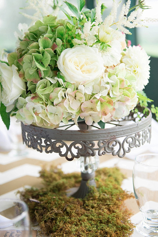 Elegant floral centerpiece on a decorative stand for a wedding table
