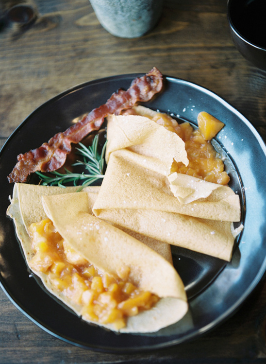 Crepes with fruit filling and bacon breakfast plate