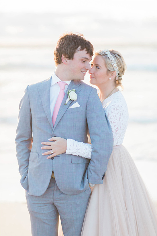 Bride and groom lovingly gaze at each other on beach wedding