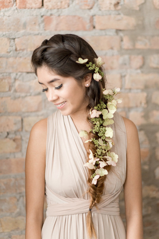 Smiling woman with flower braid hairstyle in beige dress