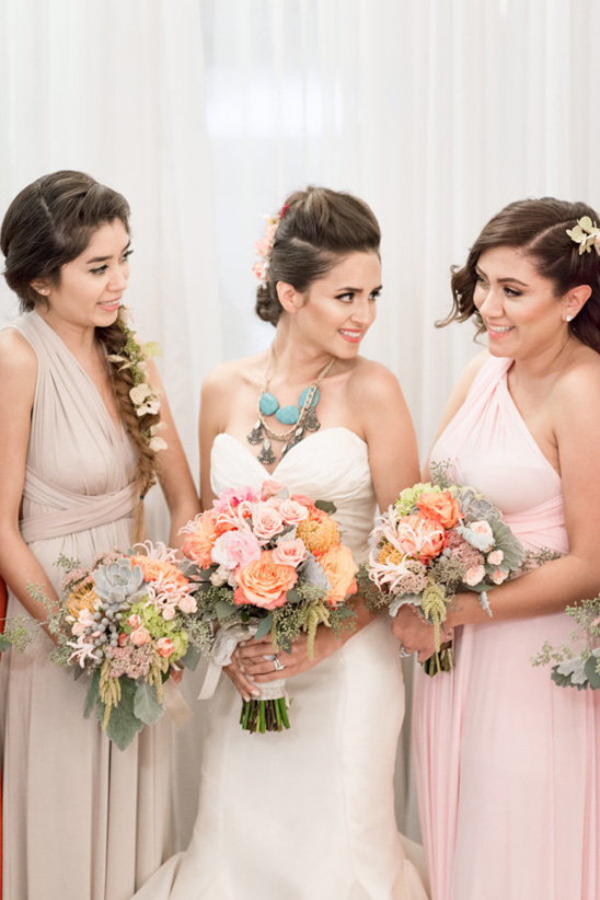 Bride and bridesmaids holding colorful wedding bouquets