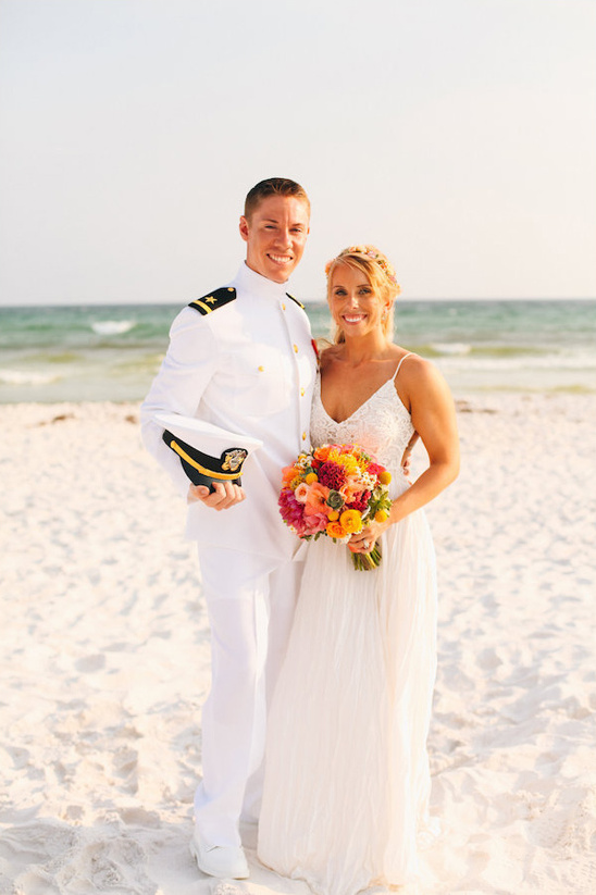 Beach wedding of smiling couple in military attire