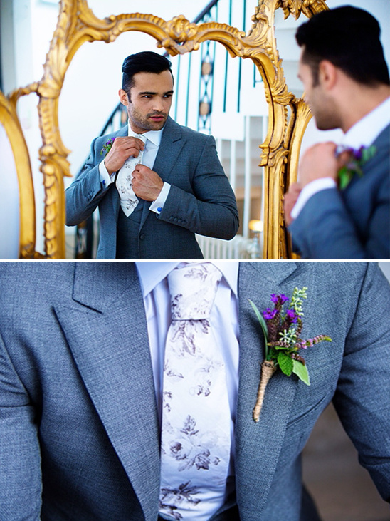Stylish groom adjusts tie in mirror before wedding event