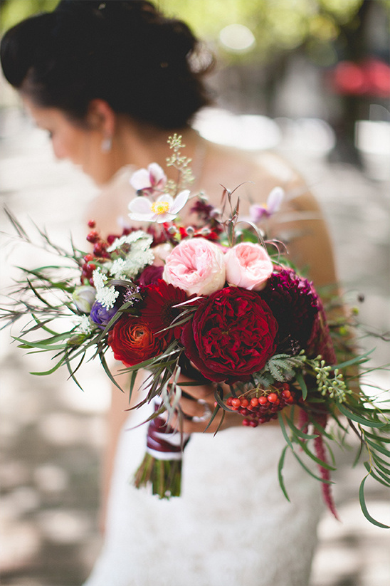Bride with dark red and pink wedding floral bouquet