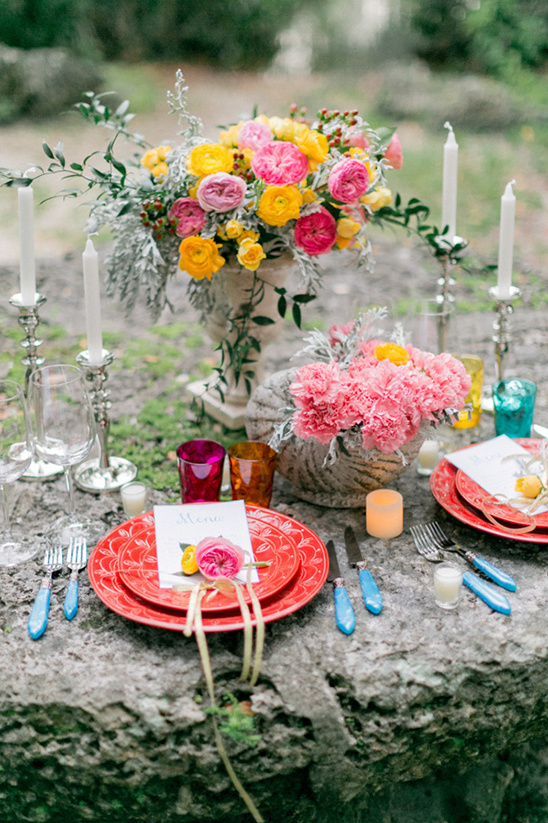 Elegant outdoor wedding table setting with bright flowers