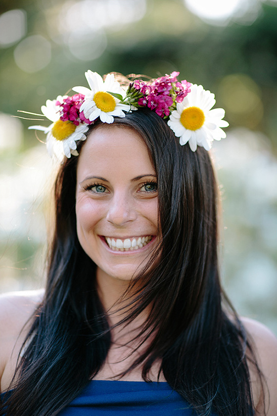 Smiling woman with flower crown of daisies and pink blooms