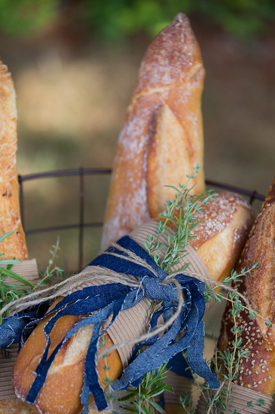 Artisan baguettes with ribbons and herbs in a basket