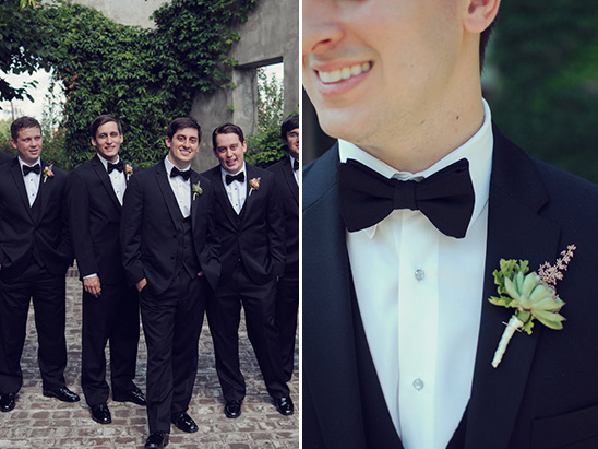 Smiling groomsmen in black suits and bow ties wedding