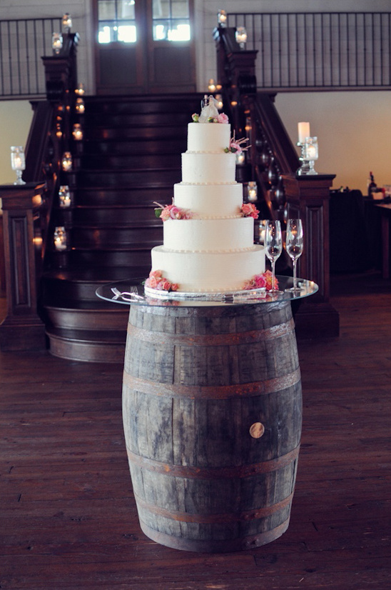 Rustic wedding cake on barrel staircase candles decor