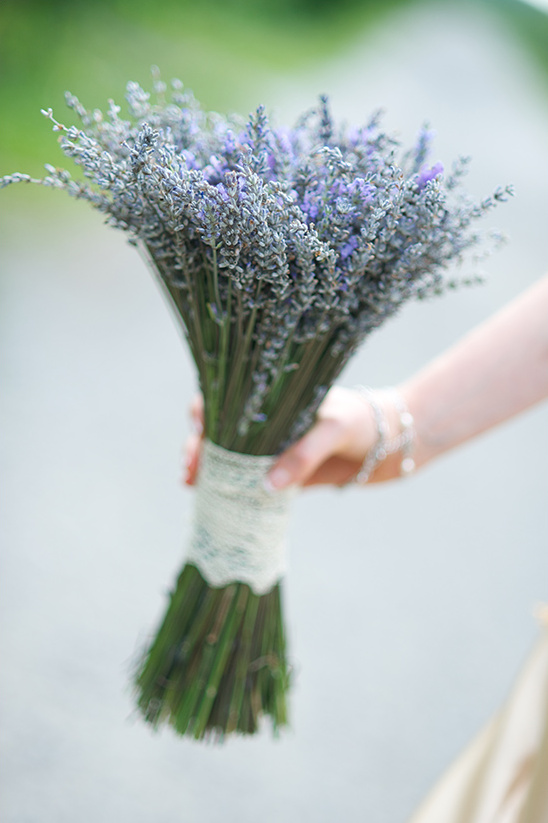 Hand holding a lavender bouquet with lace wrap