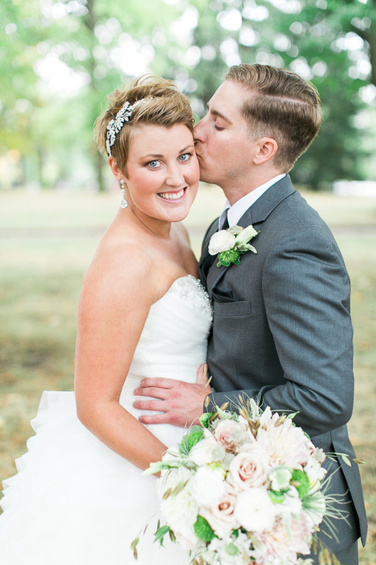 Happy groom kisses smiling bride on their wedding day