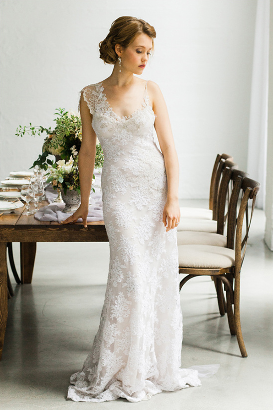 Bride in a lace wedding dress near reception table