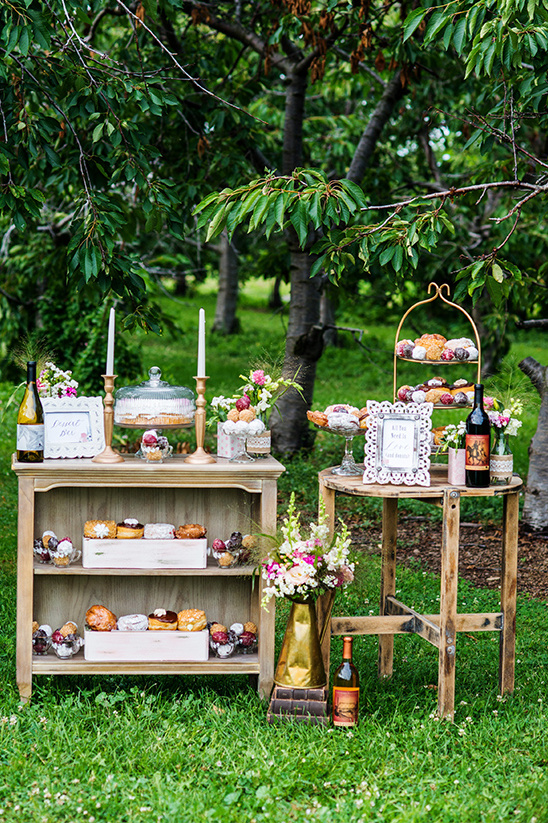 Garden party dessert display with cakes and wine bottles