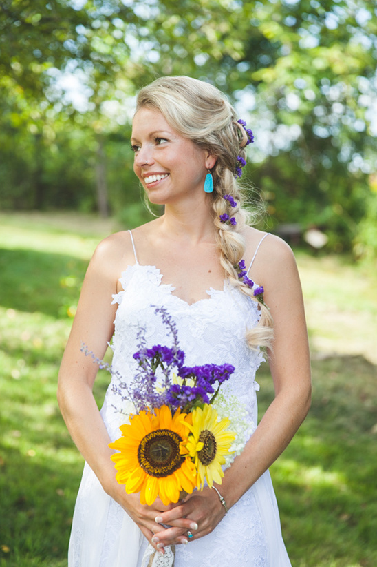 Smiling bride holding sunflowers and wearing blue earrings