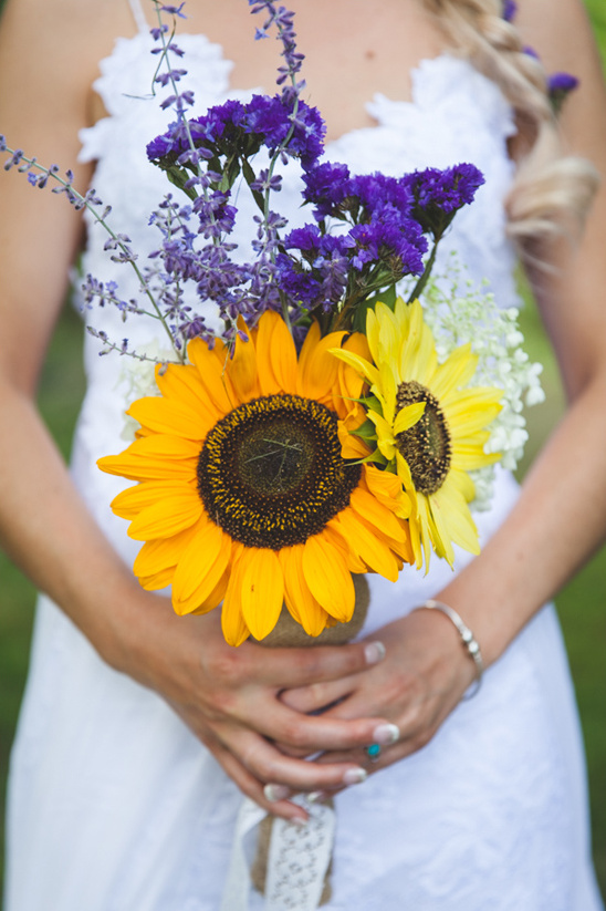 Bride holding sunflower and lavender wedding bouquet