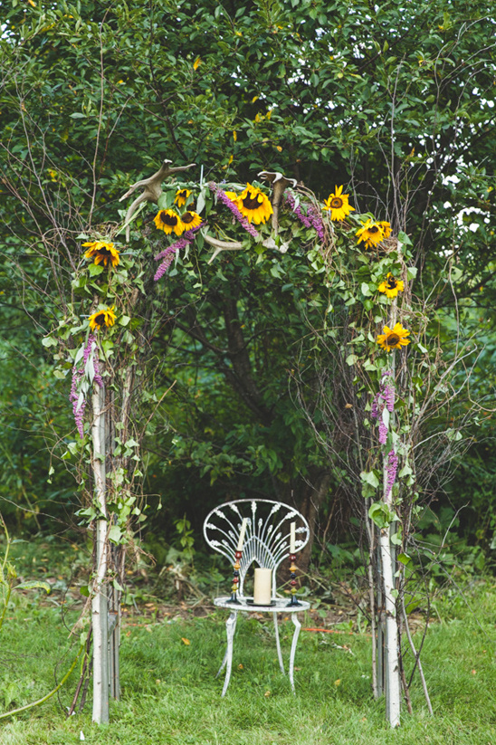Rustic sunflower archway with antlers and white chair