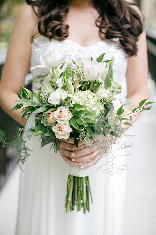 Elegant bride holding white pink tulip rose bouquet