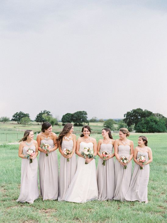 Bride and bridesmaids in matching dresses in field