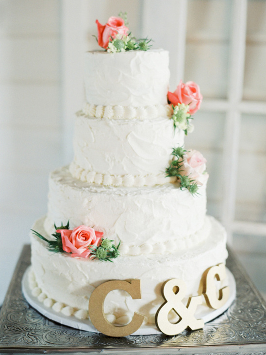 Elegant four tier wedding cake with roses and initials
