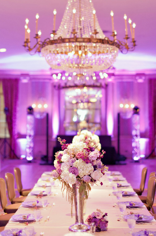 Elegant wedding reception with chandelier and purple flowers