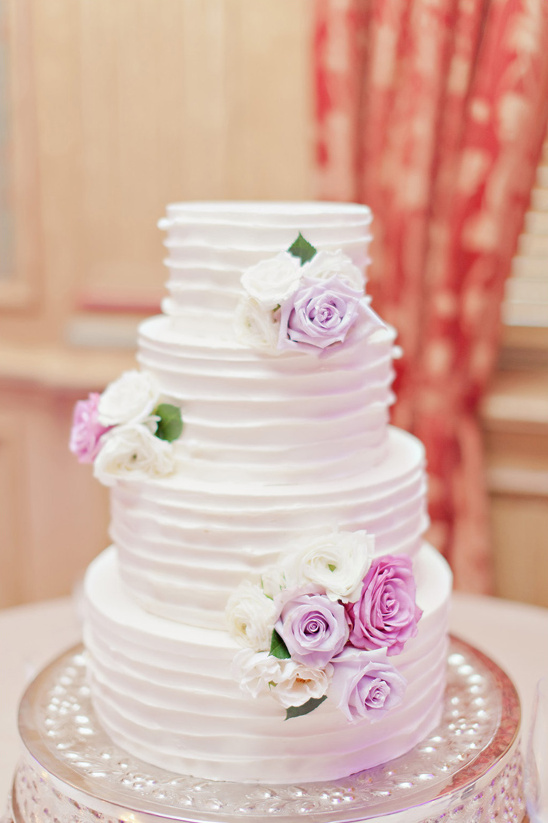 white ruffle cake with purple flower accents