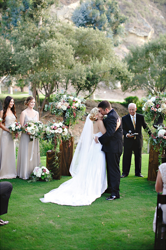 Bride and groom kissing at garden wedding ceremony