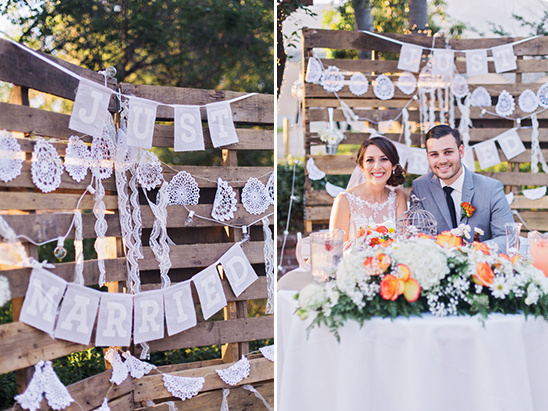 Newlyweds at rustic wedding with just married banner