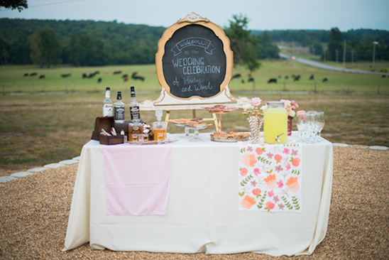 Outdoor wedding bar with drinks and celebration chalkboard