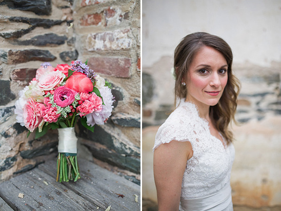 Bride in lace dress and her flower bouquet by a stone wall