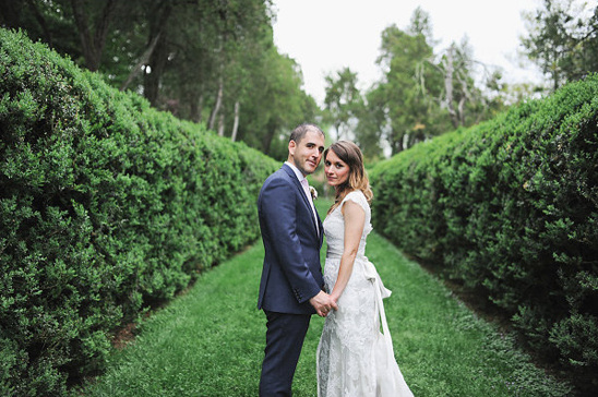 Newlyweds holding hands in a garden wedding portrait