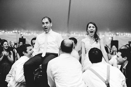 Groom and bride lifted in the air during wedding reception