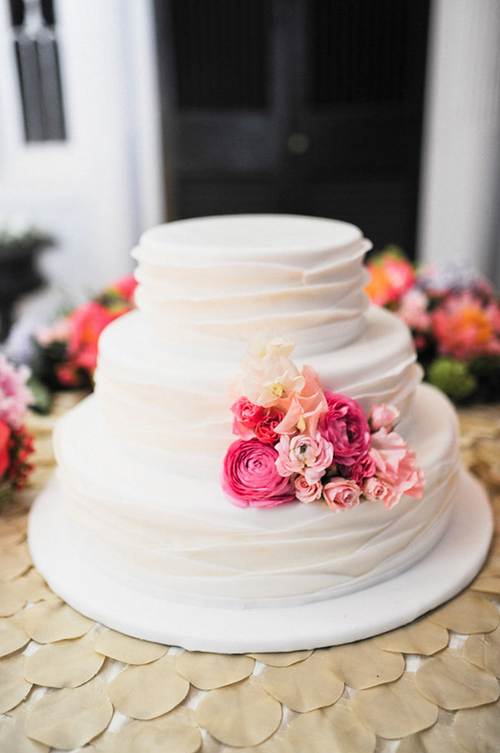 Elegant three-tiered wedding cake with floral accents on display