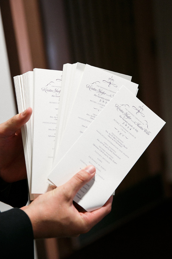 Hands hold stack of wedding programs Kristin Shafer Austin Miller