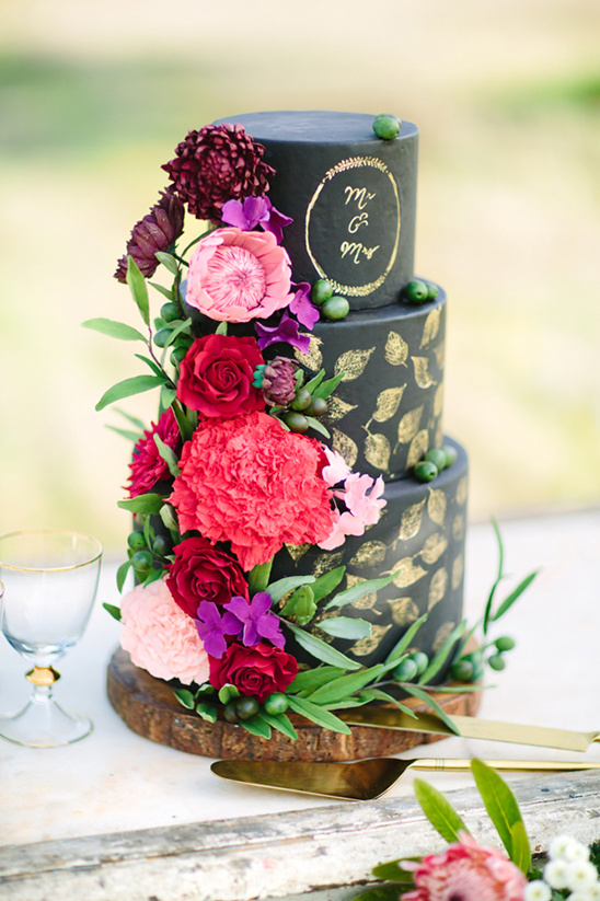 black and gold cake with floral cascade