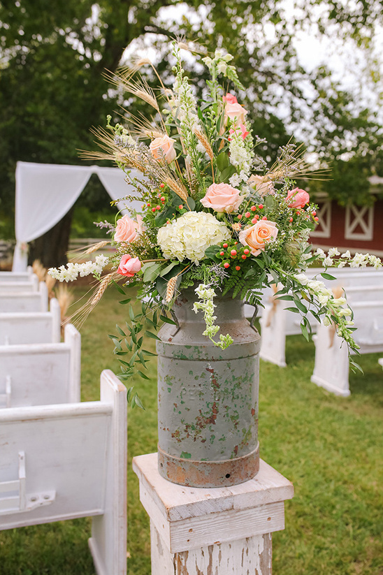 Wedding ceremony flowers pink roses in milk can vase