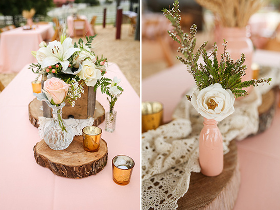 Rustic wedding table decor with flowers and candles on pink linen