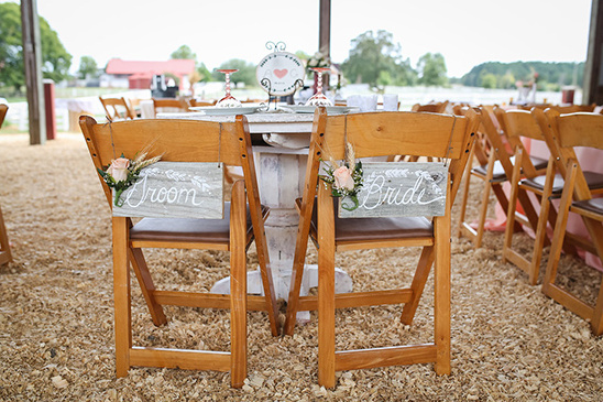 Rustic wedding chairs marked Groom and Bride at a ceremony
