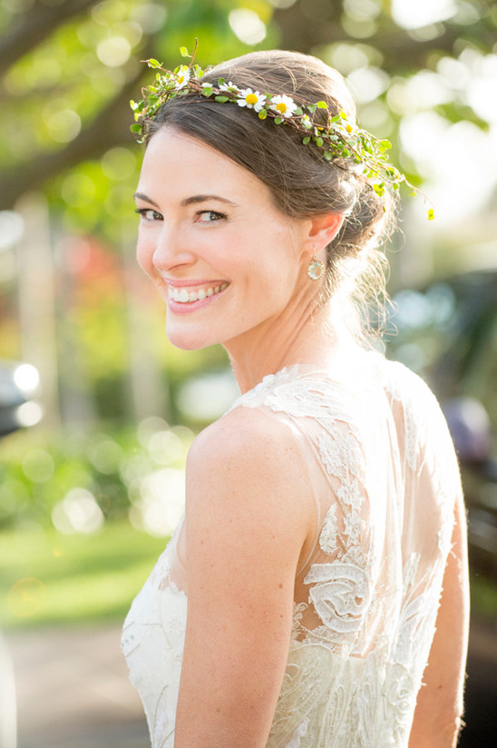 Smiling bride wearing a floral crown and lace wedding gown