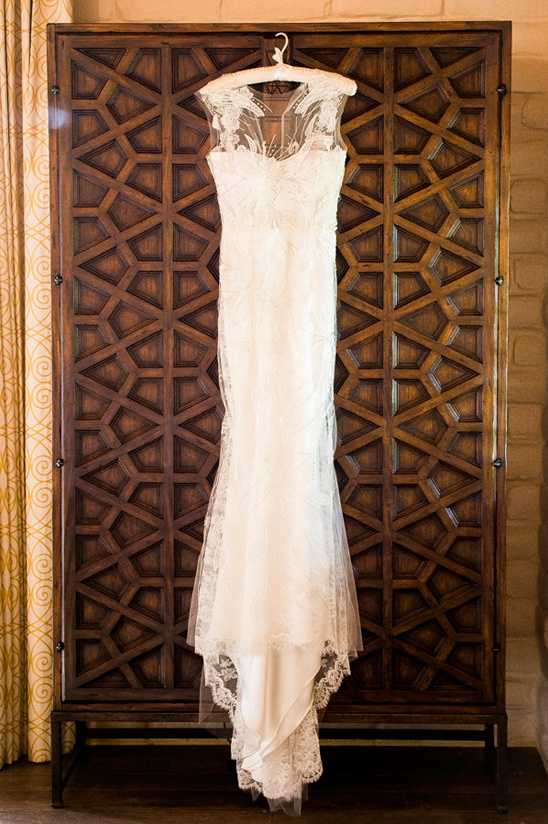 Elegant lace wedding dress hanging on vintage wardrobe