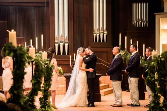 Bride and groom share first kiss at church wedding ceremony