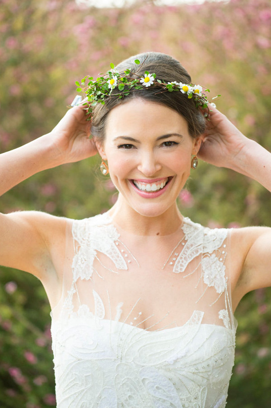 Happy bride with daisy crown adjusting her flower wreath