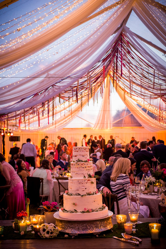 Magical wedding tent reception with cake and lights