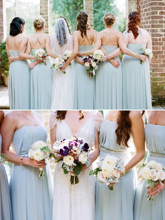 Wedding bride and bridesmaids in blue dresses from behind with flowers